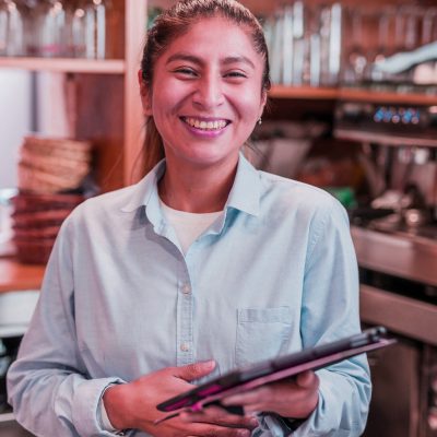 small business woman owner using tablet technology. young Peruvian Latinx bistro entrepreneur friendly person from Peru south America small business use digital tablet and internet for her small business morning organization.